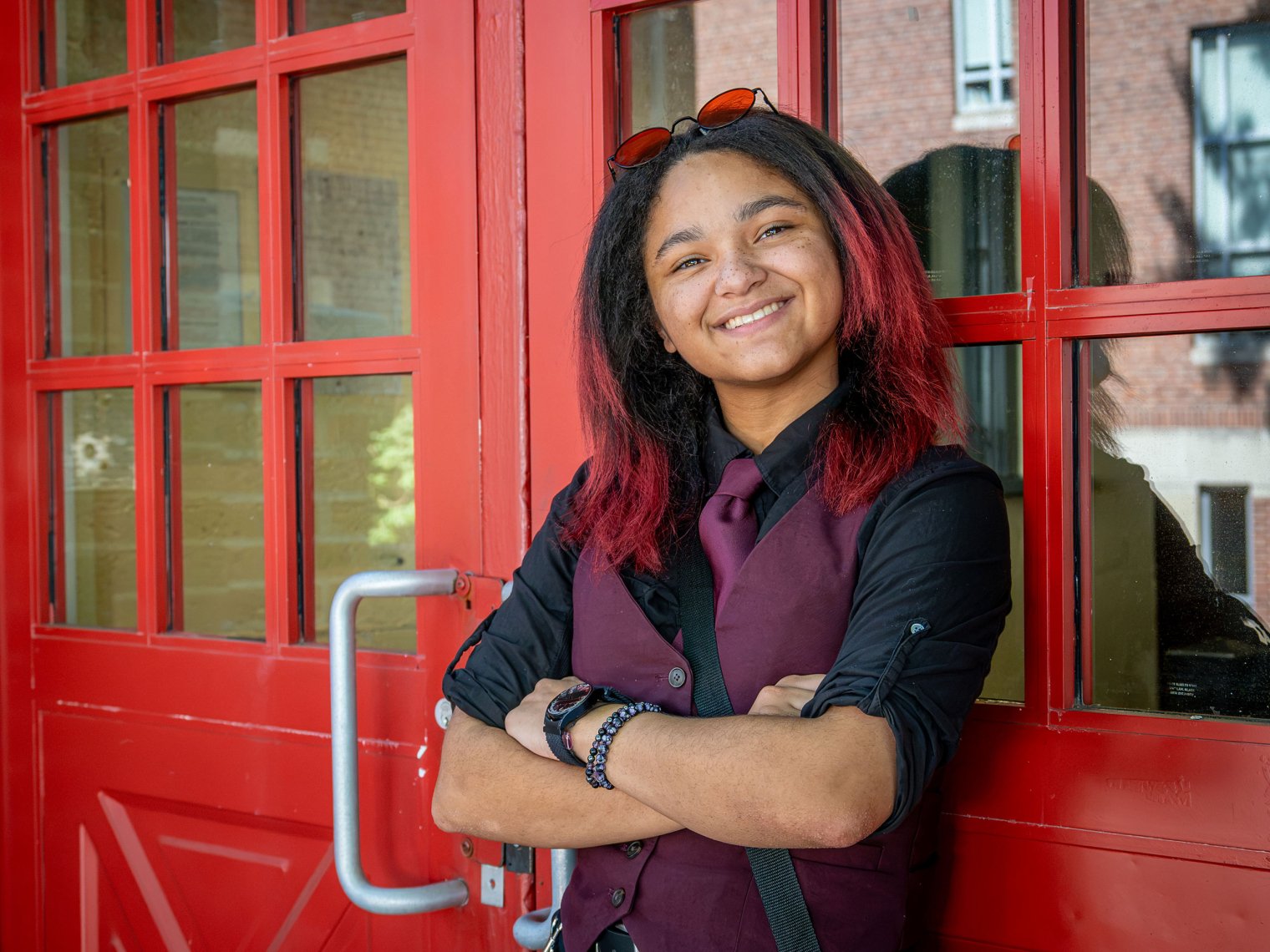 Student Sabrina Towell leaning against red door at Bloomfield campus