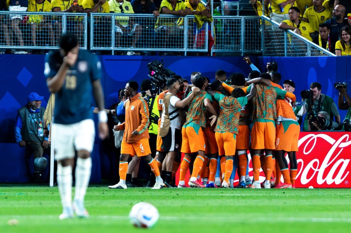 A World Cup team celebrates its goal as an opposing player walks away. 