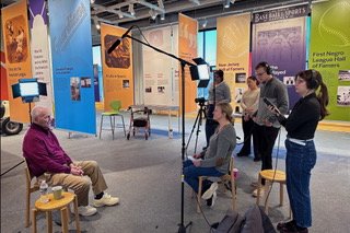 A film crew interviews a Paterson man for an oral history.