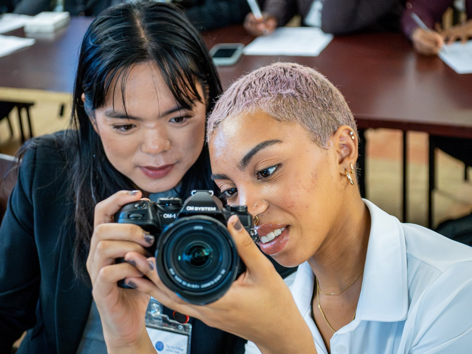 Two students look at a camera's viewfinder.