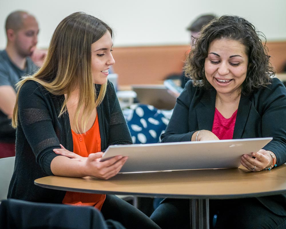 Student and mentor reviewing a presentation
