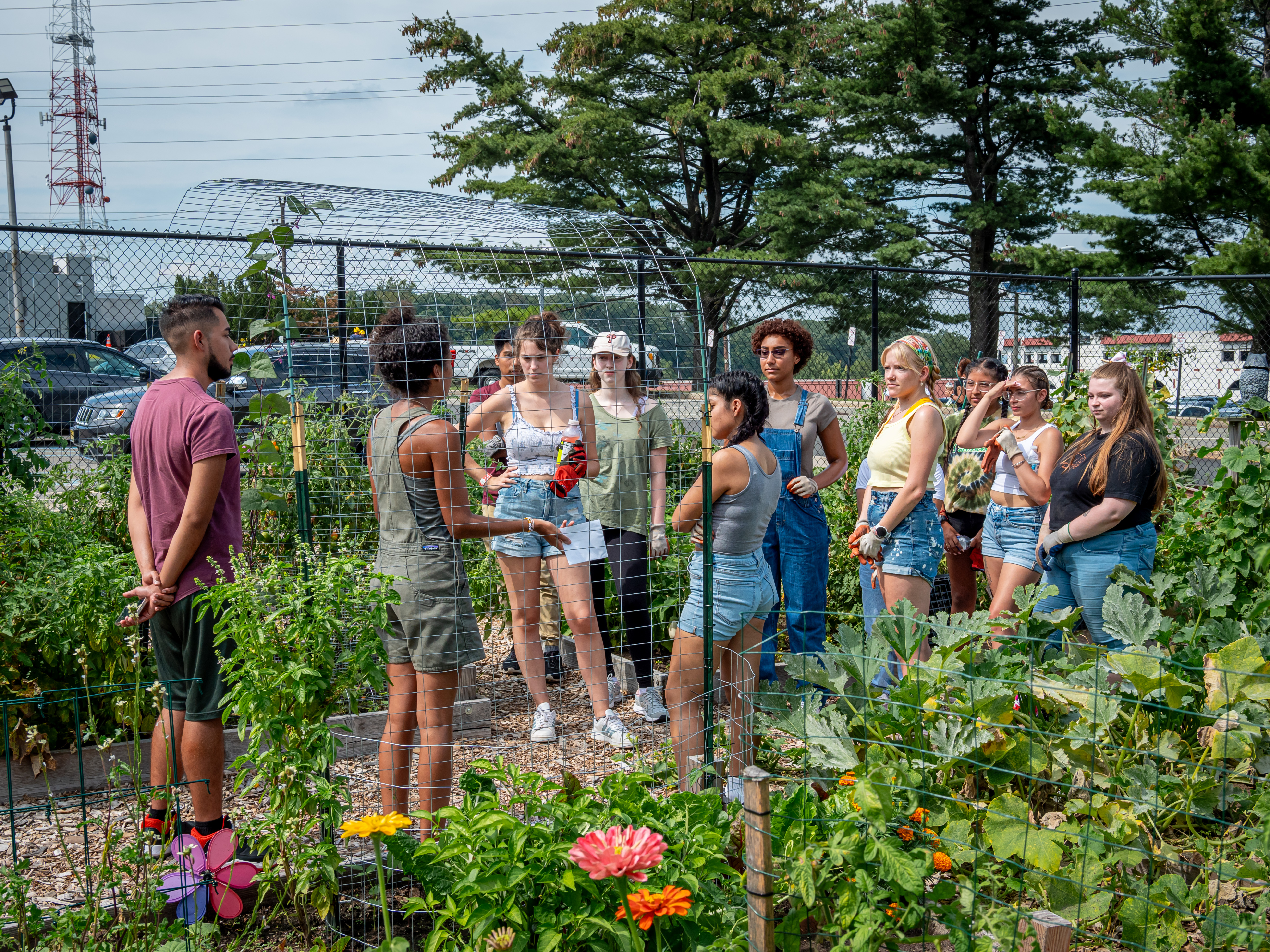 Garden Manager, Brittney Portes, speaks to a group of student gardeners in the middle of the garden space.