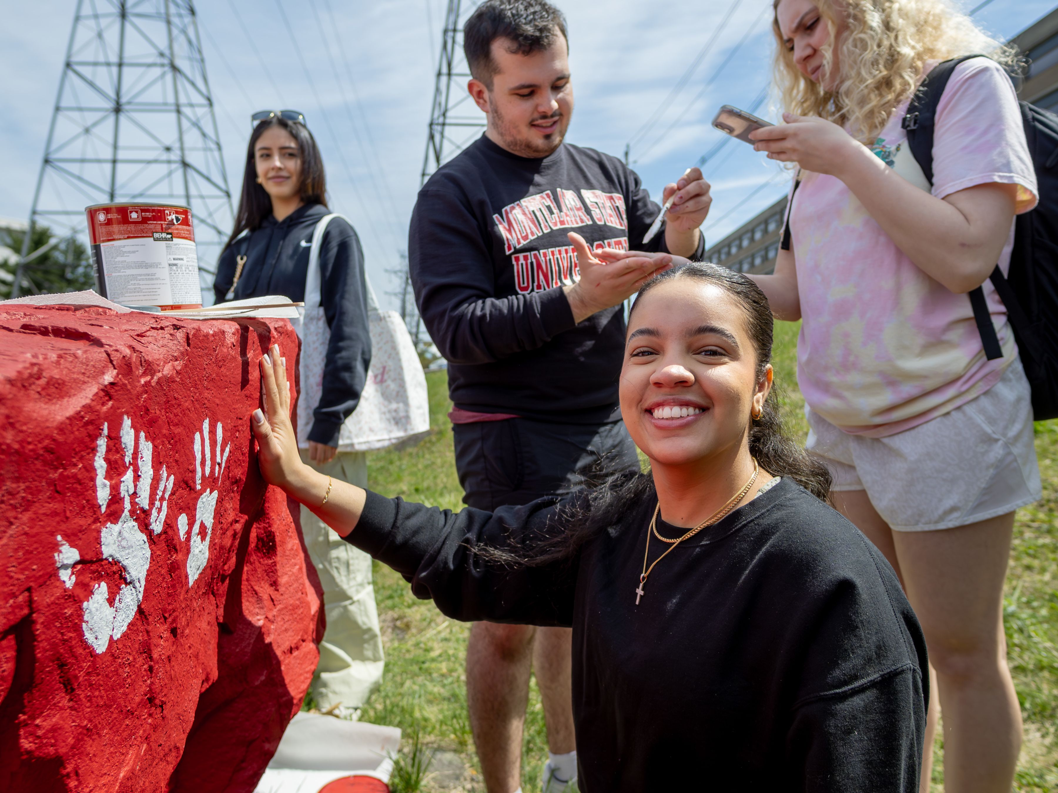 Student Media Ambassadors pose with the red-painted rock