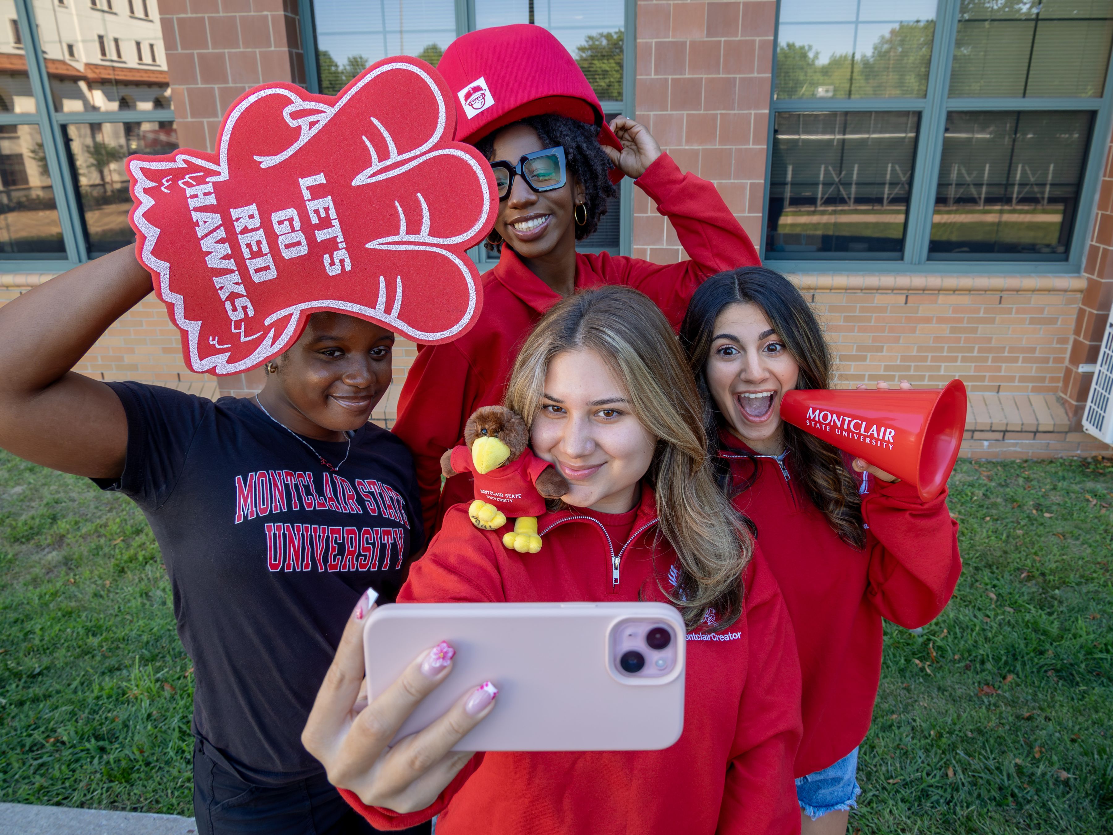 Four social media ambassadors pose with props for a selfie